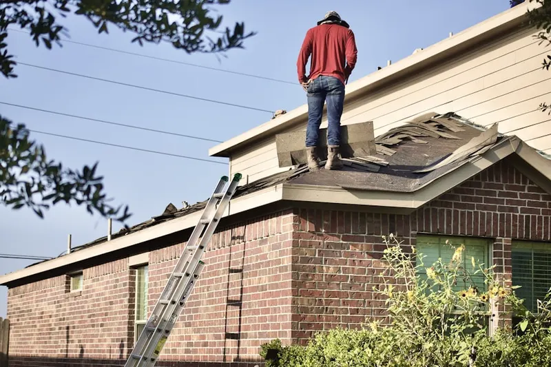 Professional roofer working on a residential roof in Selden